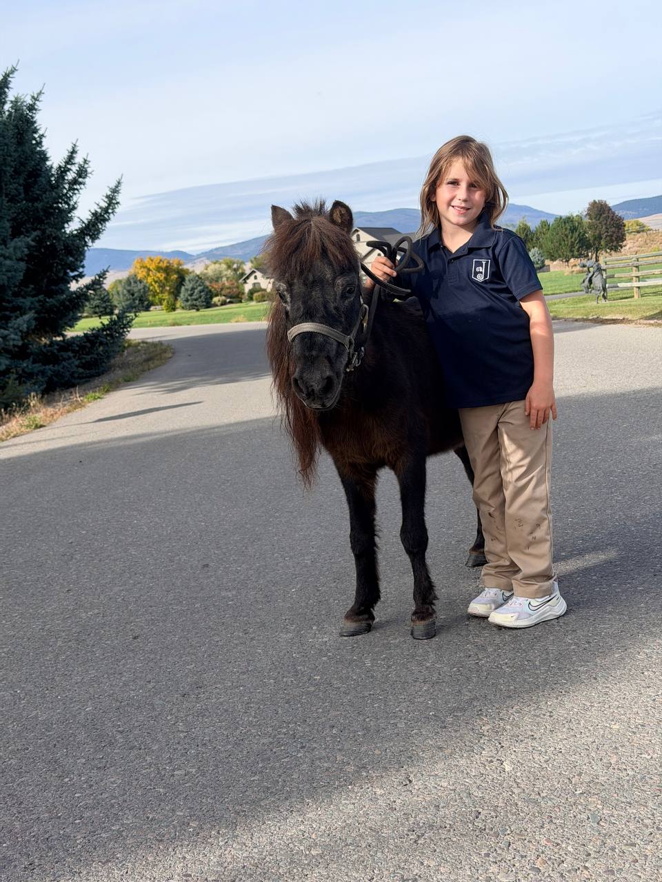 Snickers the mini pony on a walk with one of our kids