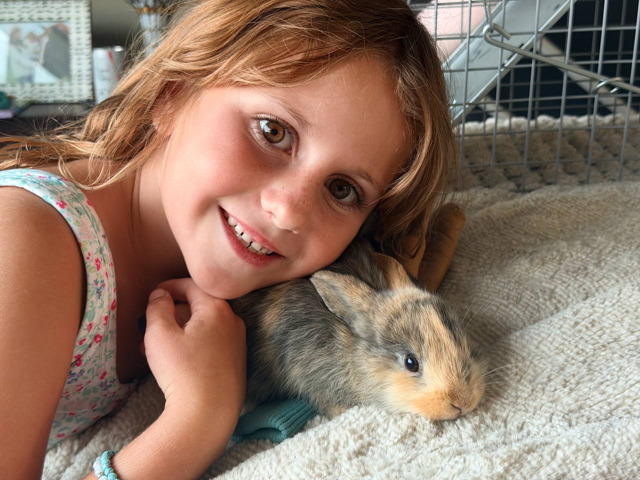 A young caretaker cheek-to-cheek with a rescued bunny